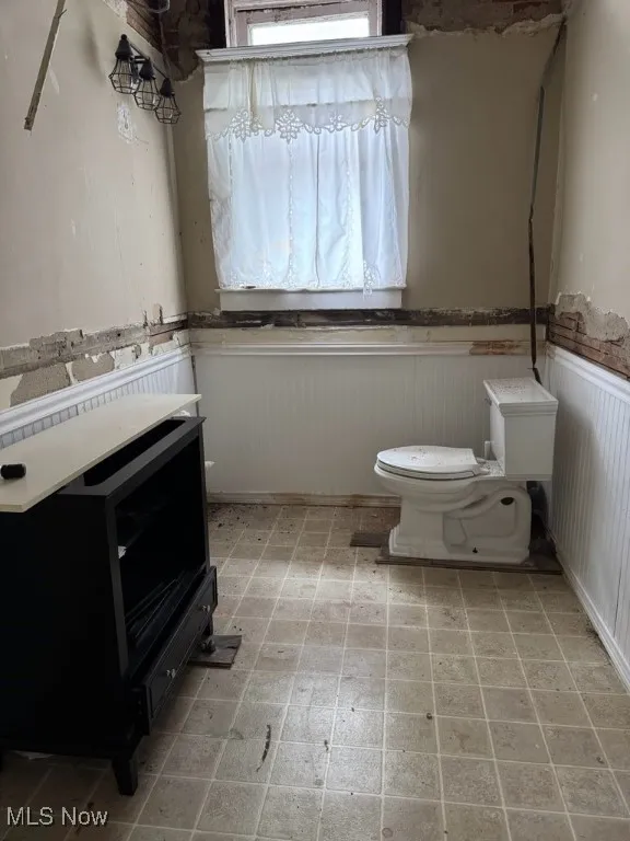 Half bath with vanity and a wainscoted wall