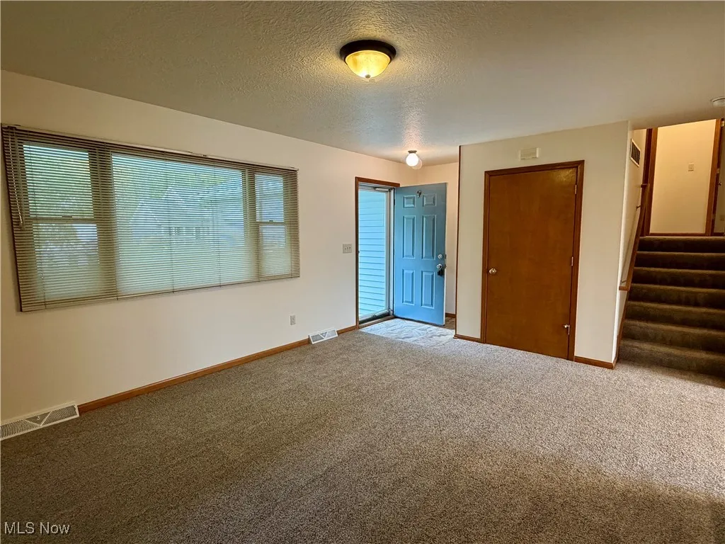 Unfurnished bedroom featuring carpet, a textured ceiling, and a closet