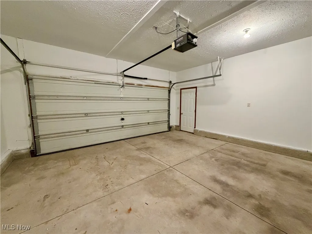 Garage with a garage door opener and baseboards