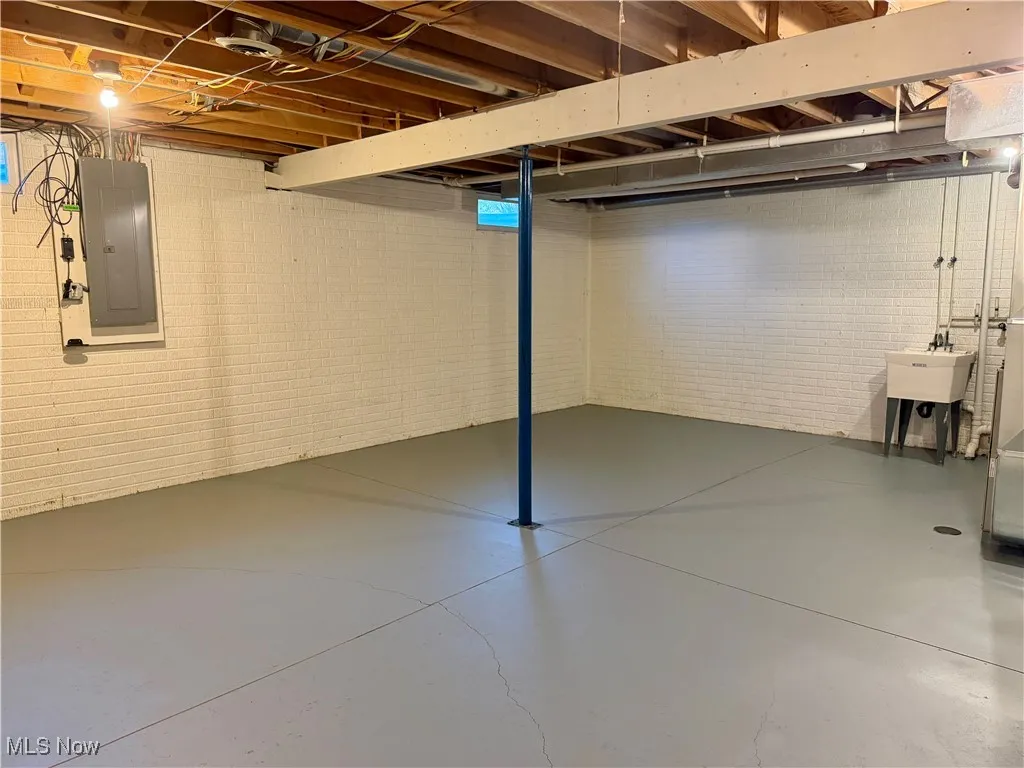 Unfinished below grade area featuring electric panel
