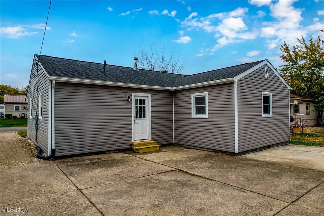 Back of house featuring a shingled roof, a patio area, and entry steps