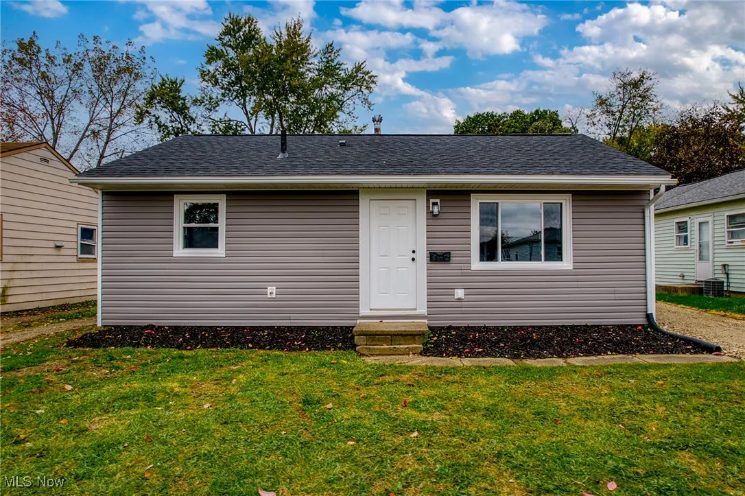 Bungalow with a front yard, entry steps, and a shingled roof