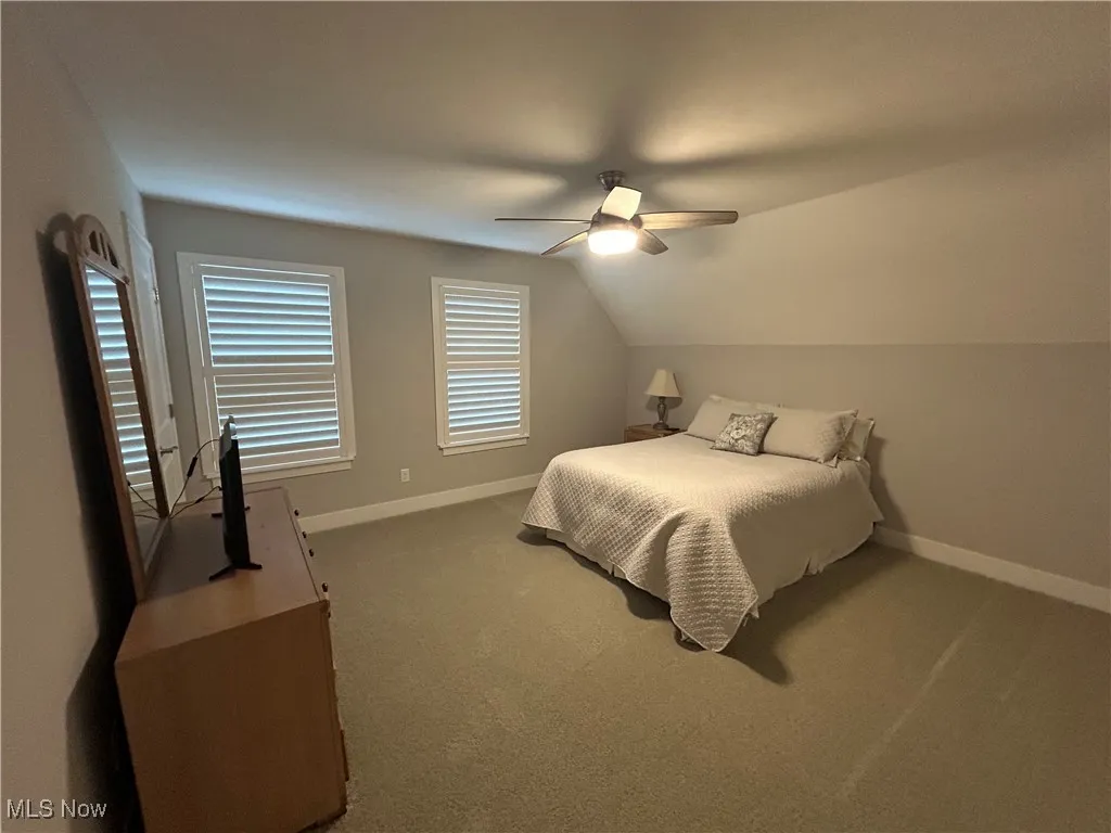 Bedroom with carpet flooring, ceiling fan, and lofted ceiling
