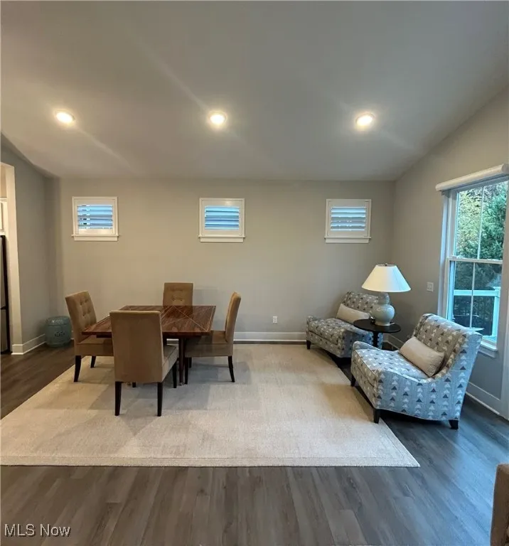 Dining room with dark wood-style floors and recessed lighting