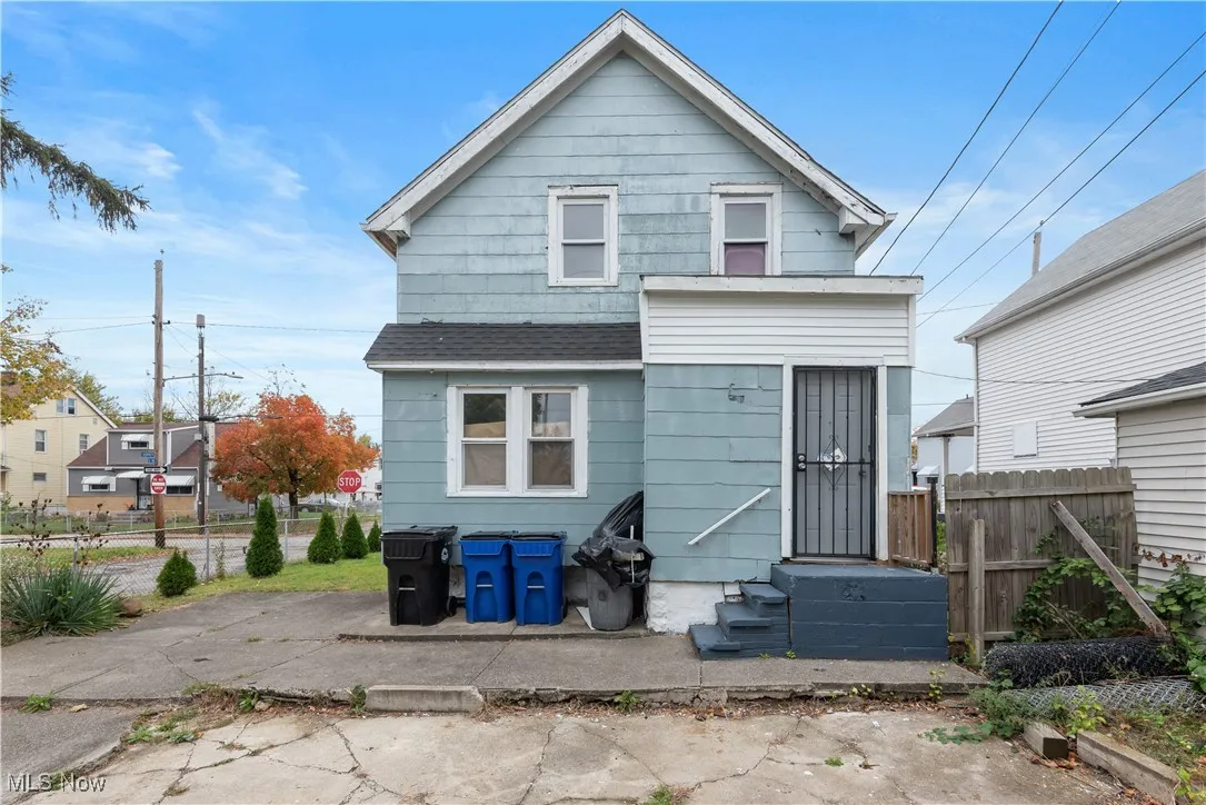 Rear view of property featuring a shingled roof and entry steps