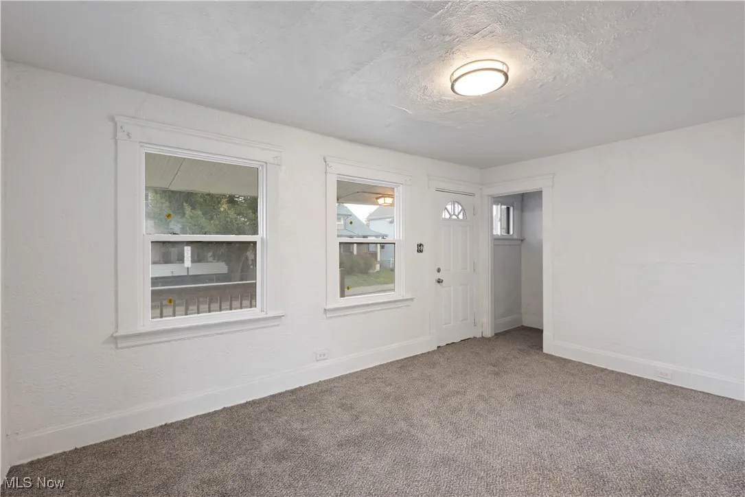 Entrance foyer with carpet and a textured ceiling