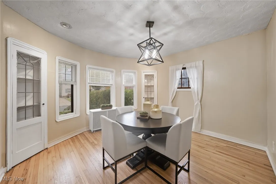 Dining space with light wood-style floors, healthy amount of natural light, and a textured ceiling