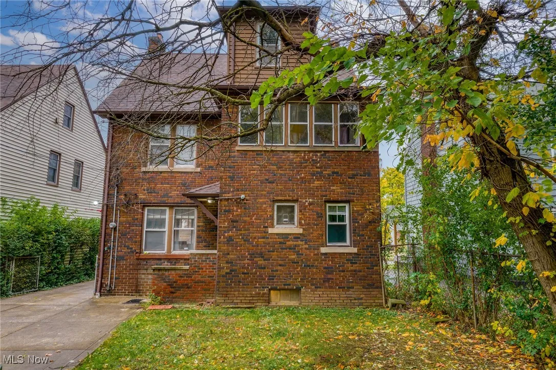 View of front facade featuring brick siding and a chimney