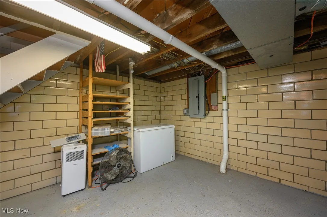 Unfinished below grade area featuring electric panel