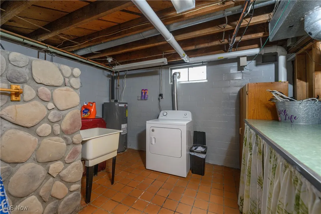 Laundry room with washer / clothes dryer, water heater, and tile patterned floors