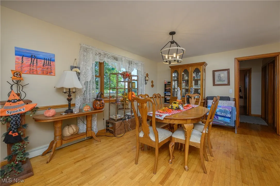 Dining area with light wood finished floors and a chandelier