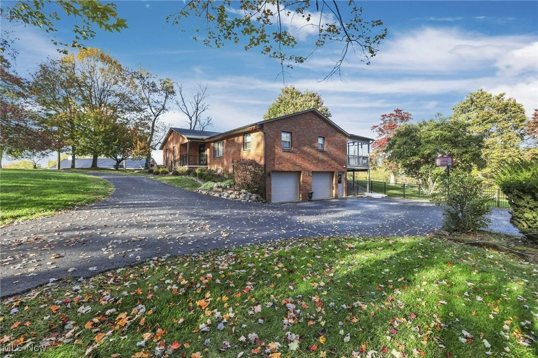 View of side of property featuring brick siding, driveway, and an attached garage