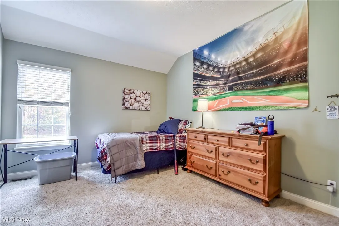 Bedroom with carpet floors and lofted ceiling