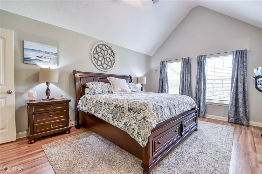 Bedroom featuring light wood-style flooring, ceiling fan, and high vaulted ceiling