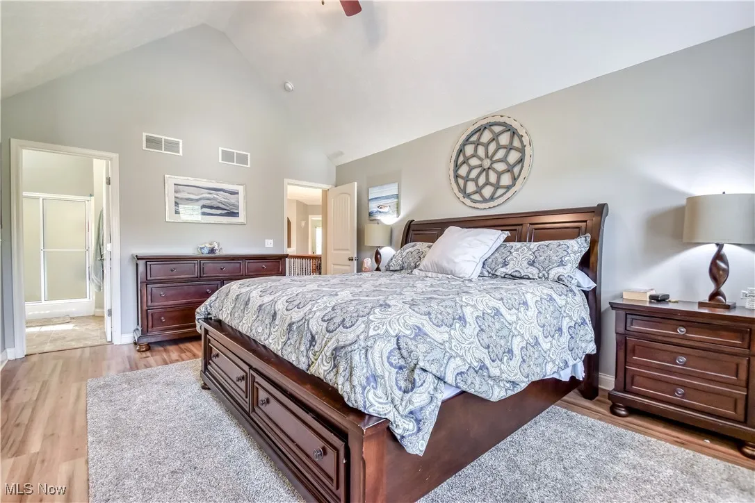 Bedroom with light wood finished floors, high vaulted ceiling, and ceiling fan
