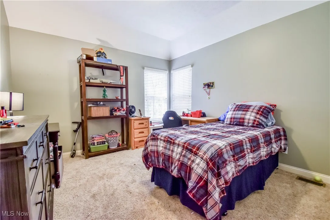 Bedroom with light carpet and baseboards