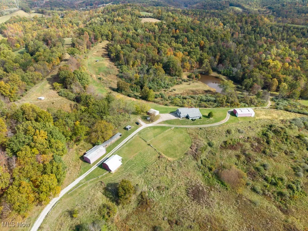 View of property location with a nearby body of water and a heavily wooded area