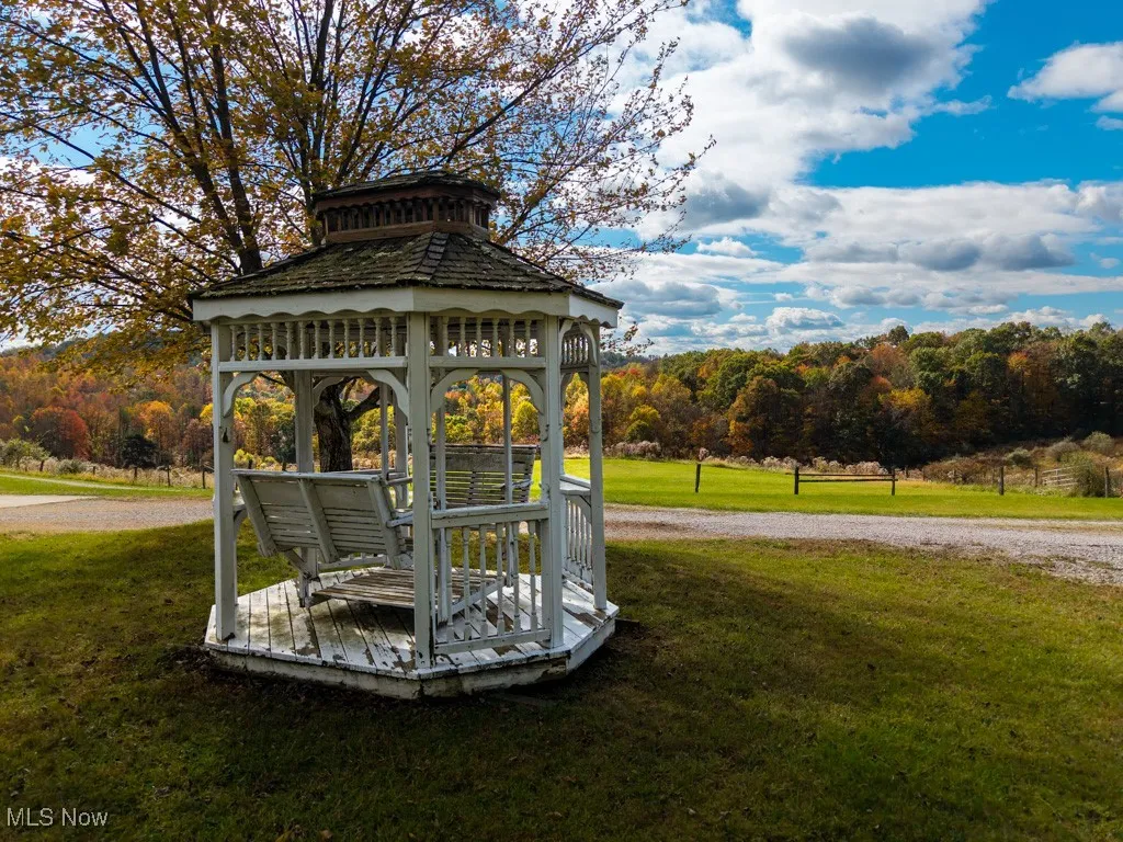 View of grassy yard featuring a gazebo and driveway