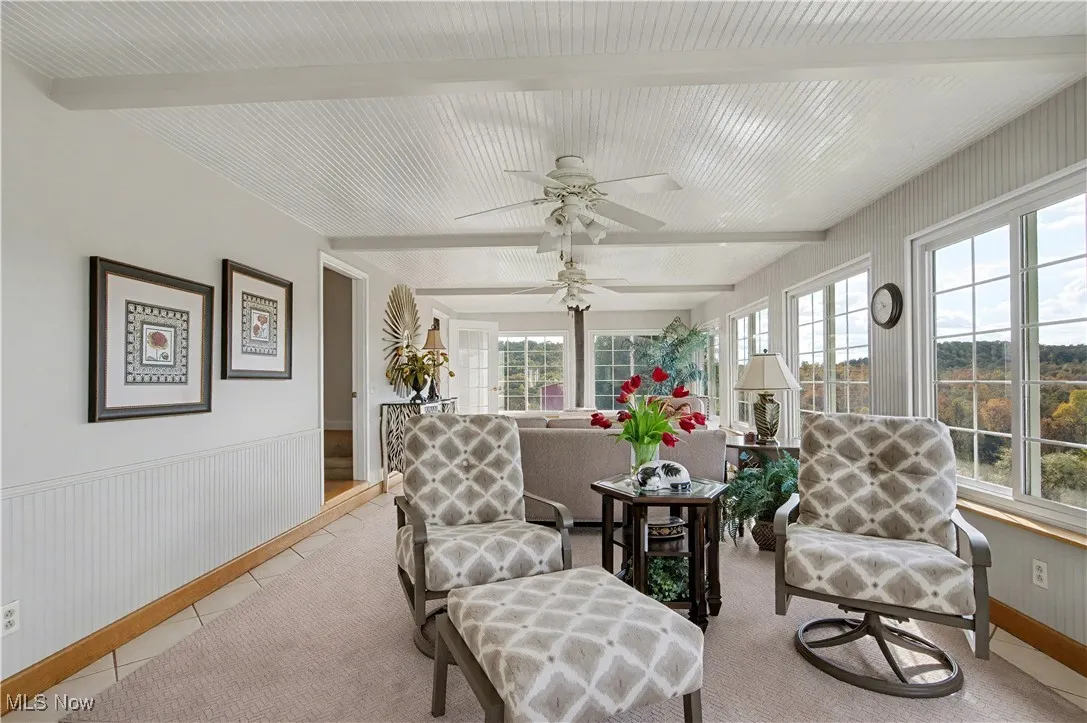 Sunroom featuring beamed ceiling