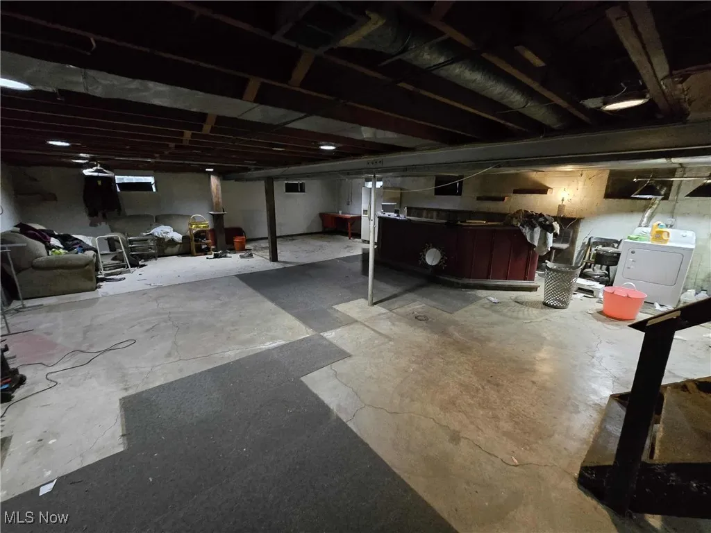 Unfinished below grade area with washer / clothes dryer