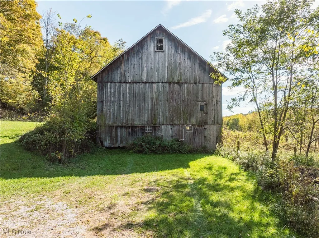 View of barn featuring a yard