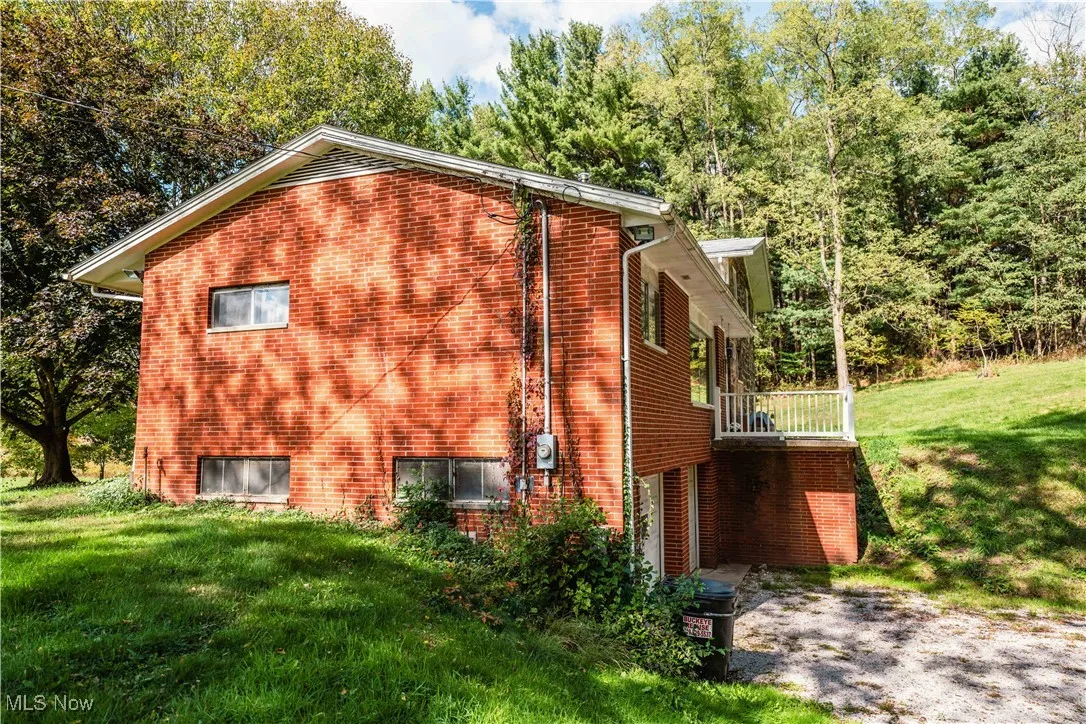 View of side of home with a yard and brick siding