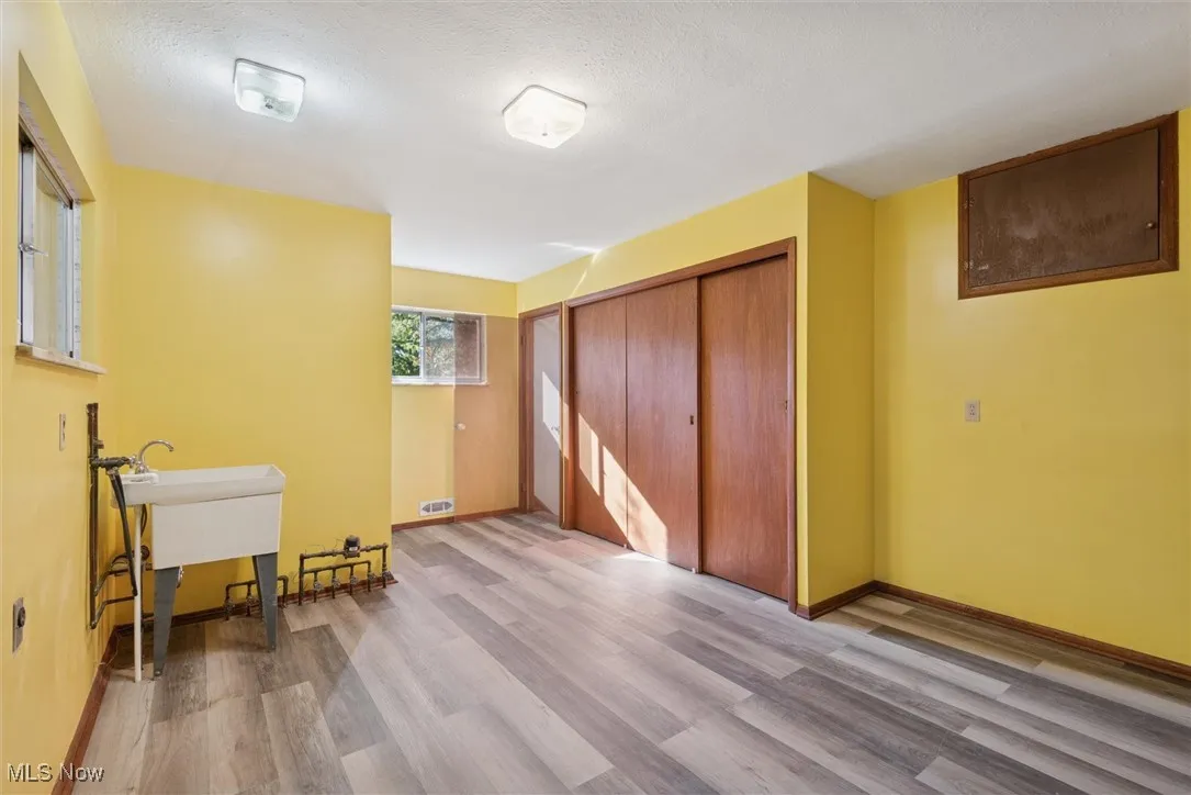 Bedroom featuring wood finished floors, a closet, and a textured ceiling