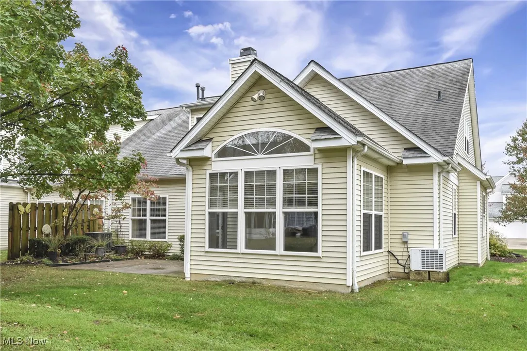 Rear view of property featuring a shingled roof, a patio, and a chimney