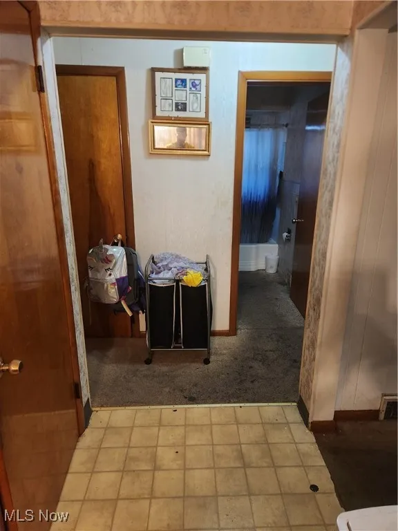 Corridor with tile patterned flooring and carpet