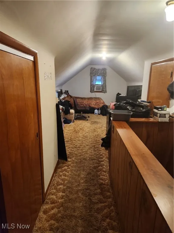 Office featuring dark carpet, vaulted ceiling, and cooling unit