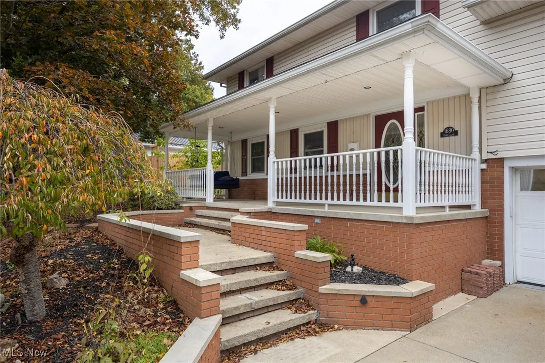View of exterior entry featuring a porch and a garage