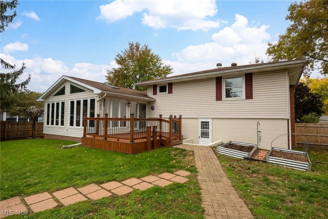 Back of property featuring a garden and a deck