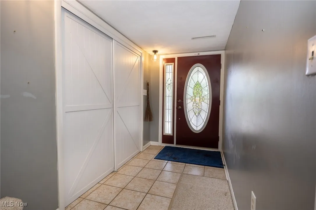 Entryway with a barn door and light tile patterned floors