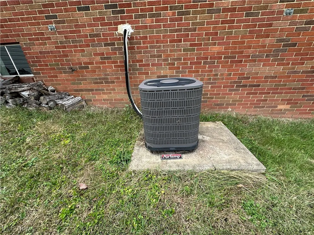 Exterior view of brick siding and a cooling unit