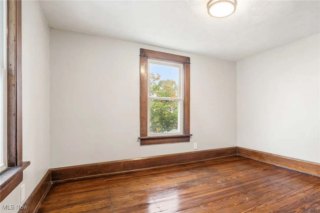 Empty room featuring hardwood / wood-style floors and baseboards