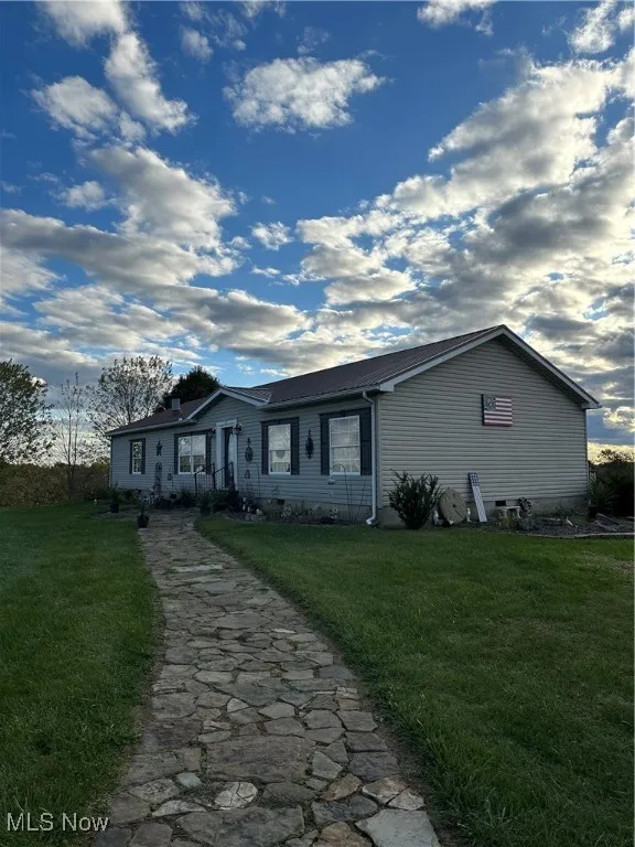 Single story home featuring a front lawn with decorative walkway