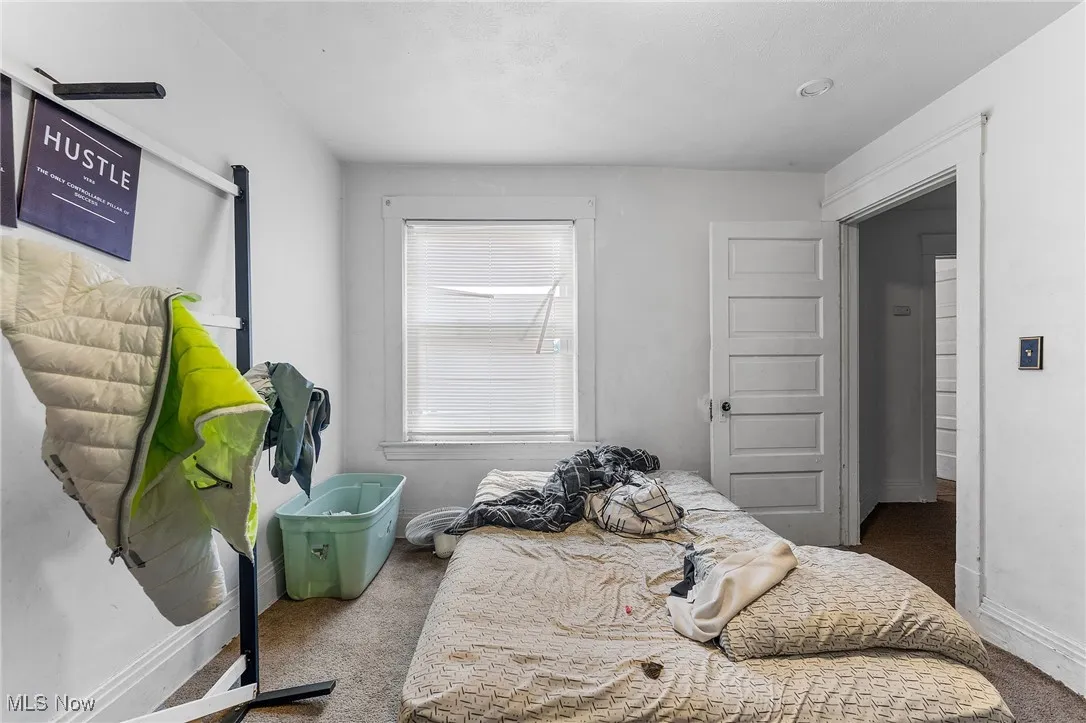 Bedroom featuring dark carpet and baseboards