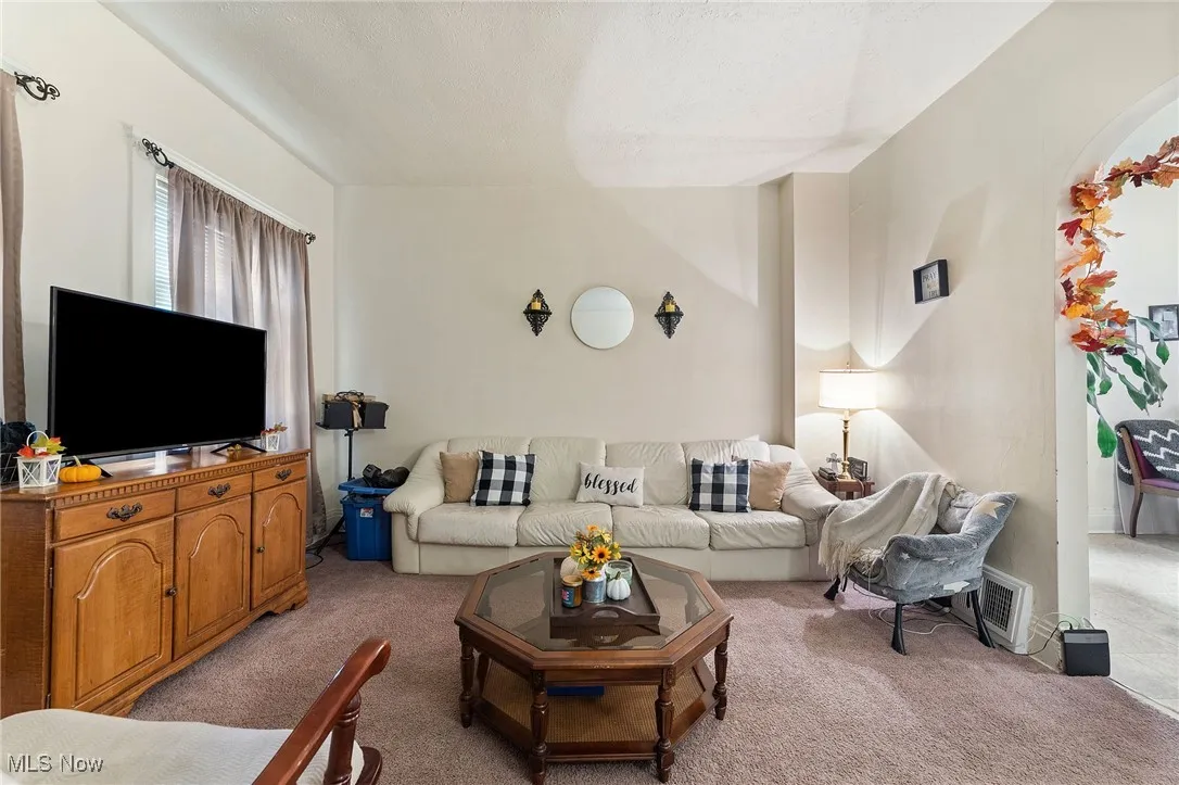 Carpeted living room with a textured ceiling