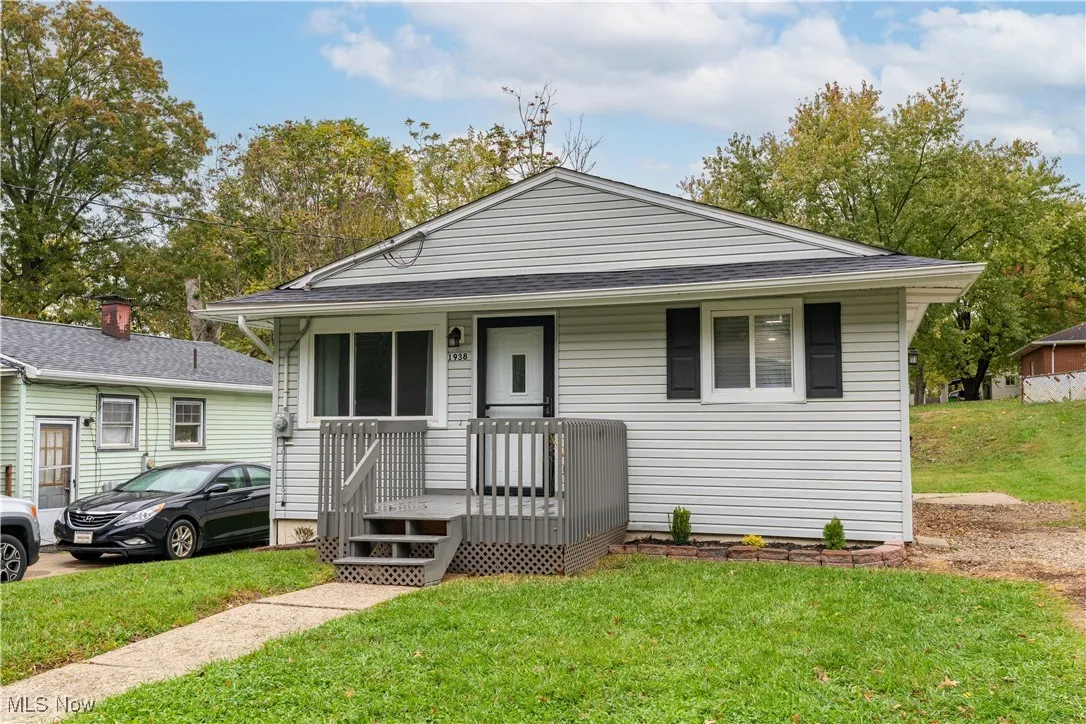 Ranch-style house with a front yard, covered porch, and roof with shingles
