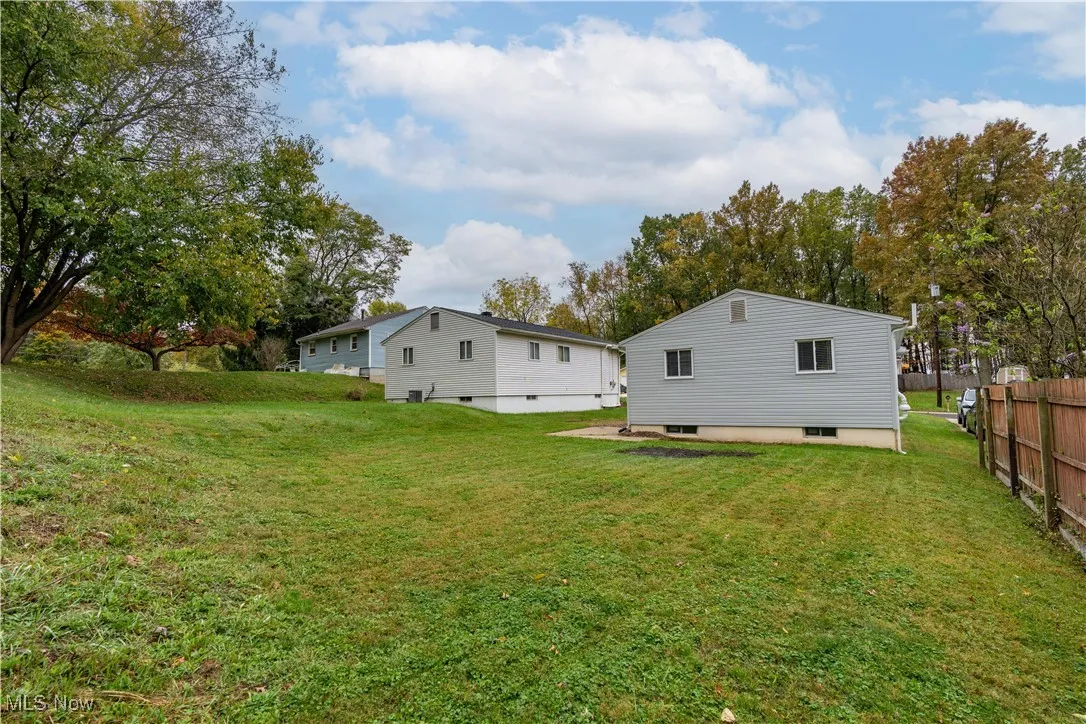Rear view of property with view of scattered trees