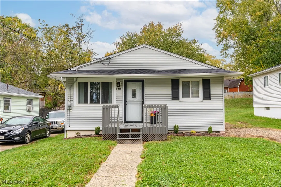 Ranch -style house with a front yard, roof with shingles, and a porch