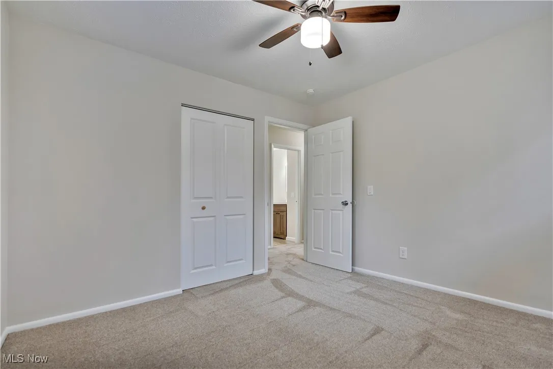 Unfurnished bedroom featuring carpet floors, a ceiling fan, and a closet