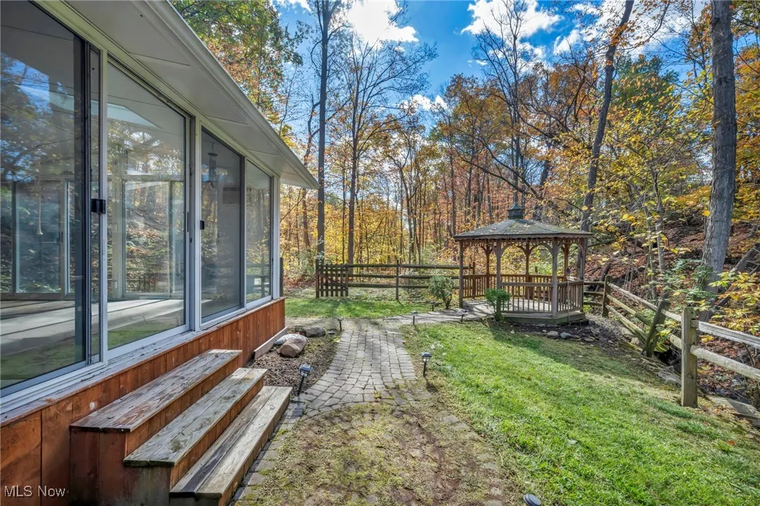 View of yard with a gazebo and a sunroom