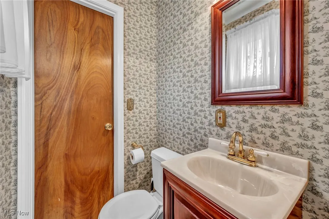 Bathroom featuring vanity and wallpapered walls