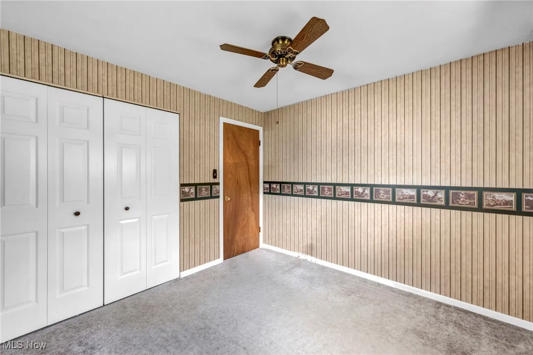 Unfurnished bedroom with a closet, ceiling fan, and carpet flooring