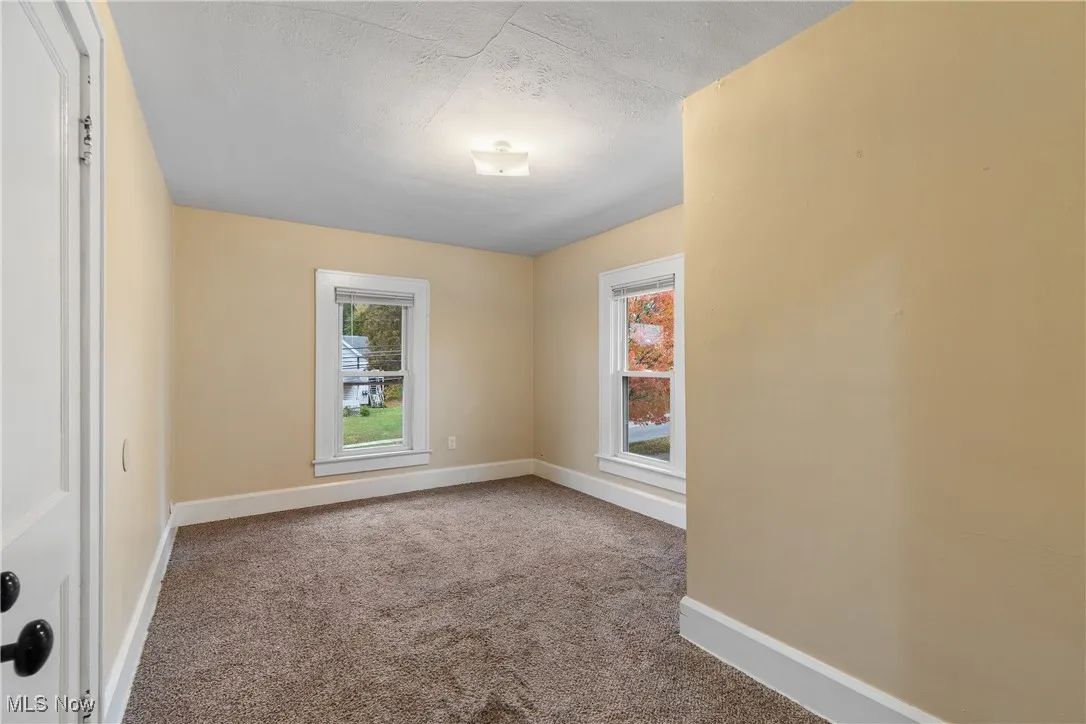 Carpeted empty room featuring healthy amount of natural light and a textured ceiling