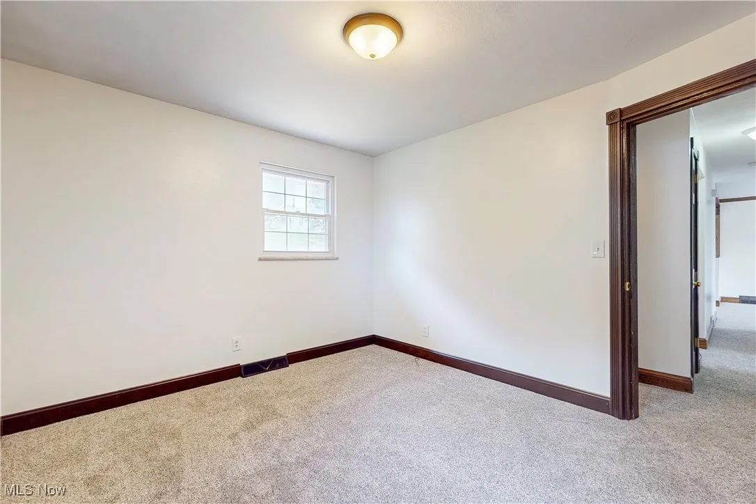 Empty room with carpet and baseboards
