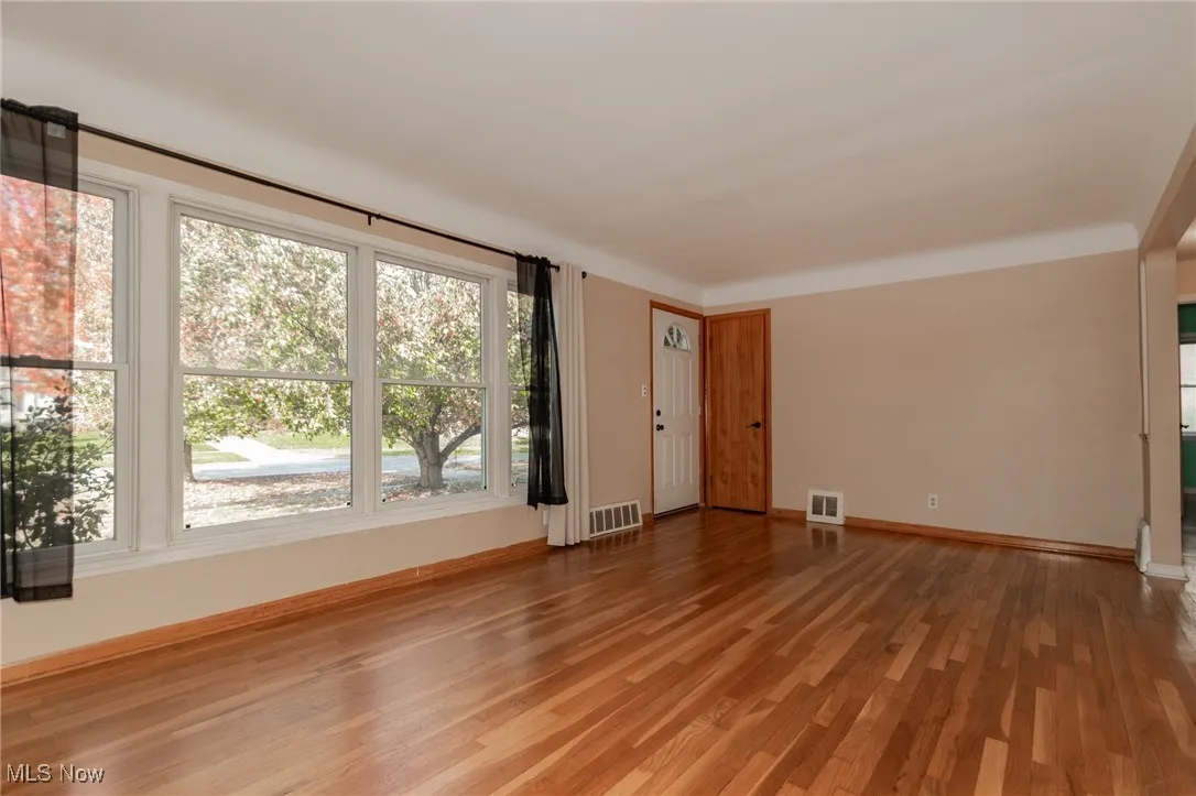 Spare room featuring light wood-style flooring and baseboards