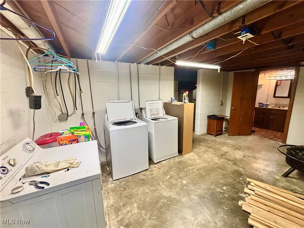 Washroom in basement featuring unfinished concrete flooring and separate washer and dryer
