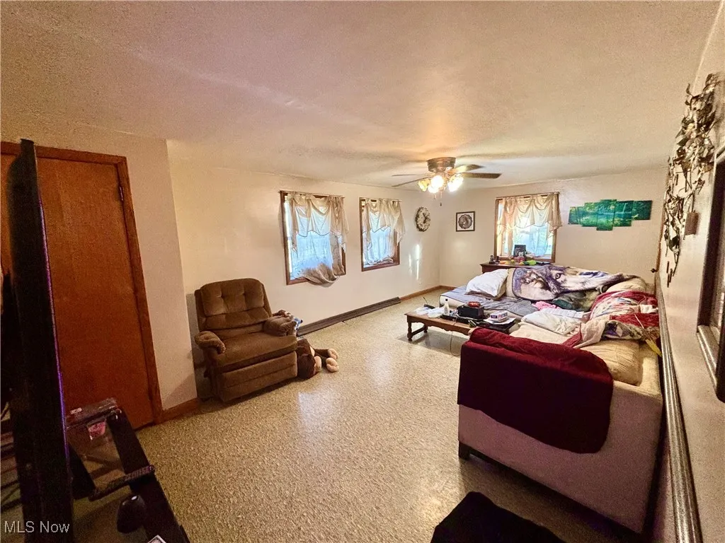 Living area featuring a textured ceiling and ceiling fan
